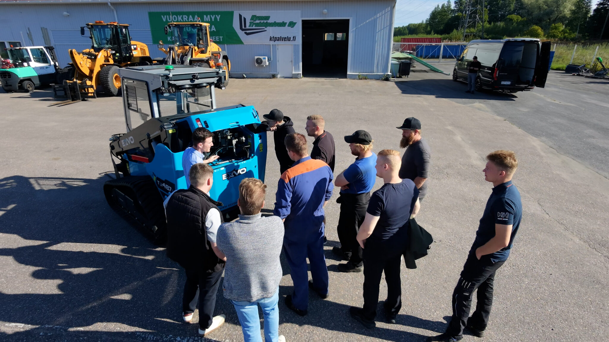 EXVO Electric -kuormaaja ja Kymen Trukkipalvelun henkilökuntaa Kymen Trukkipalvelun toimipisteen pihalla.